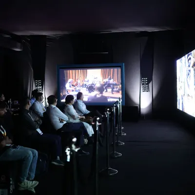 Attendees experience a live home cinema demonstration, showcasing the immersive power of high-fidelity audio and large-screen projection in a dedicated, acoustically treated room.