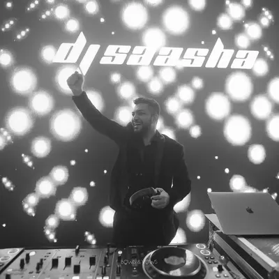 A moment of pure joy behind the decks. This black and white shot captures me in my element, with my logo lighting up the background. It's more than just playing music; it's about creating an unforgettable night.