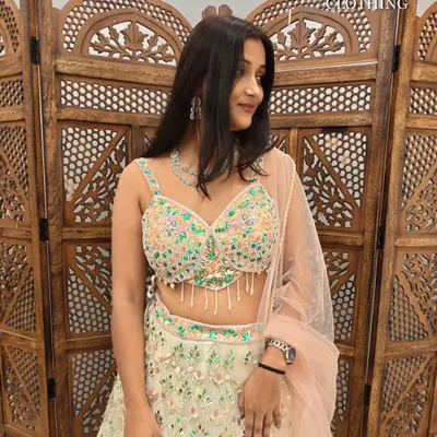 This light green lehenga with multi-color floral embroidery and a peach dupatta is a fresh and fun choice for a Mehendi.
