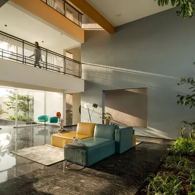 The double-height entrance lobby of "The Treehouse" apartments is filled with natural light, creating a welcoming transition from the city outside. This space is part of a central social core that connects residents vertically through the building.