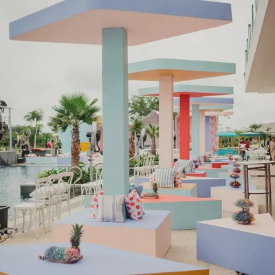 A poolside brunch with a modern twist. We designed and built these rhombus-shaped canopies and triangular seating blocks in a palette of fresh, happy pastels, creating a fun and geometric landscape.