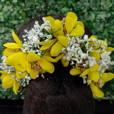 A vibrant yellow and white floral hair veni, perfect for a Haldi ceremony or a spring wedding. This beautiful hair accessory is available for purchase.