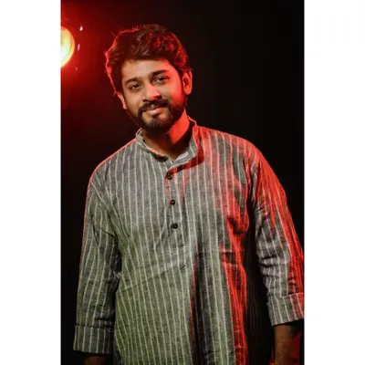 A smiling portrait from a studio session in a striped kurta. This demonstrates my ability to convey a warm and positive expression under directed lighting, suitable for lookbooks and brand catalogues.