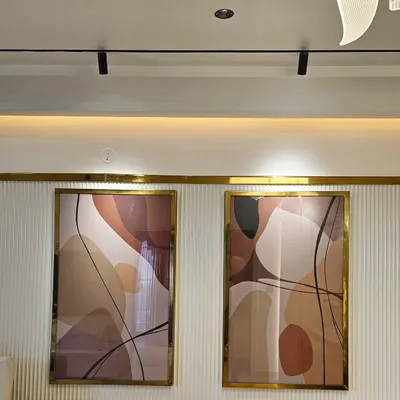 A close-up of a custom diptych I created for a client's home. The artwork features flowing abstract shapes in a warm, neutral palette, elegantly framed in gold to match the interior accents.