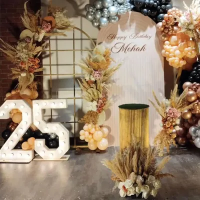 A full view of the stunning boho-chic setup for Mehak's 25th birthday. The decor features large marquee numbers, a custom backdrop, and an elaborate arrangement of balloons and dried pampas grass.