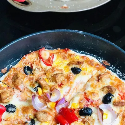 A classic homemade pizza, baked until golden and bubbly. I use a generous amount of cheese, chicken, and fresh vegetables like bell peppers, onions, and olives for a perfect bite every time.
