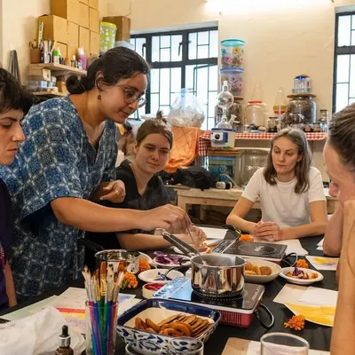 Our instructor, Sudha, demonstrates the process of extracting pigment during a botanical ink workshop. Participants gather around to learn how to turn simple, natural ingredients into a palette of beautiful, earthy colors.