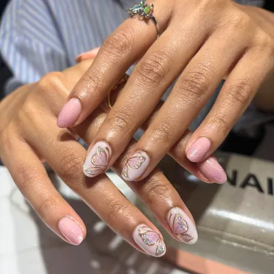A delicate and feminine design featuring a soft pink base with intricate butterfly wing art. The gold detailing adds a touch of sparkle, creating a look that is both subtle and enchanting.