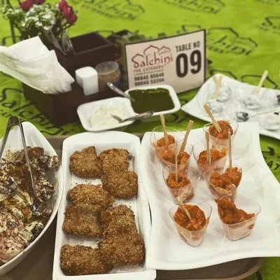A platter of our delicious starters ready to be served. This spread includes our crispy fried cutlets, a creamy chicken dish, and another appetizer in shot glasses, showcasing the variety and presentation we offer for your event's menu.