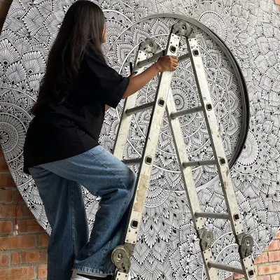 Up on a ladder, adding details to the massive 10 foot mandala mural in Malaysia. This project required focus, patience, and a steady hand.