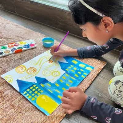 A young artist channeling her inner Van Gogh! Here she is, creating the beautiful swirls of a 'Starry Night' sky. It's a wonderful way to learn about brushstrokes and color.