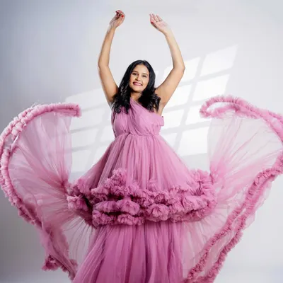 A moment of pure joy captured in our pink ruffled gown. The movement of the dress adds a dynamic and celebratory feel to this solo maternity portrait.