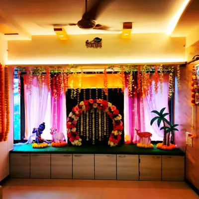 A beautiful Vrindavan-themed Ganpati decoration for the home. This setup features a floral arch, props like a Krishna idol and a cow, and traditional marigold garlands.