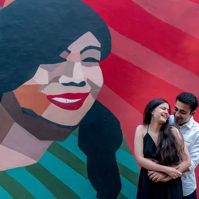 A fun and vibrant shot against a colorful graffiti wall in Delhi. Urban art provides a fantastic, modern backdrop for a themed engagement shoot that is full of personality.