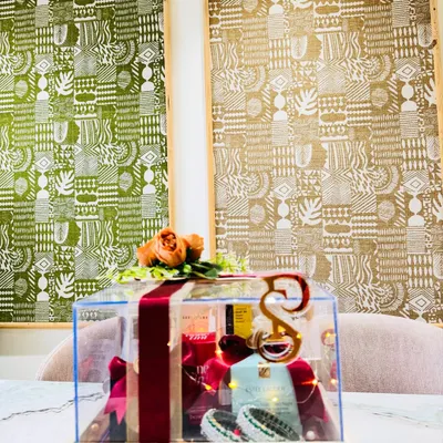 A stunning acrylic trousseau box curated with makeup must-haves from brands like Estée Lauder and Bobbi Brown. The box is adorned with a custom initial, traditional bangles, and floral accents.