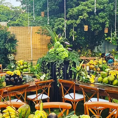 This was the showstopper for a rustic sit-down dinner. The tables were decorated with an abundance of fruits and foliage, including bananas, coconuts, and pineapples, all sourced from the client's own farm for a true farm-to-table experience.