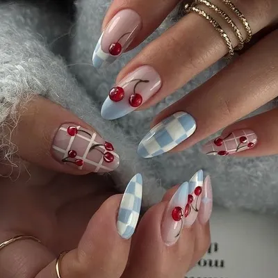The cherry nail trend is so cute and versatile. Here it's paired with a baby blue checkerboard pattern for a playful, retro vibe.