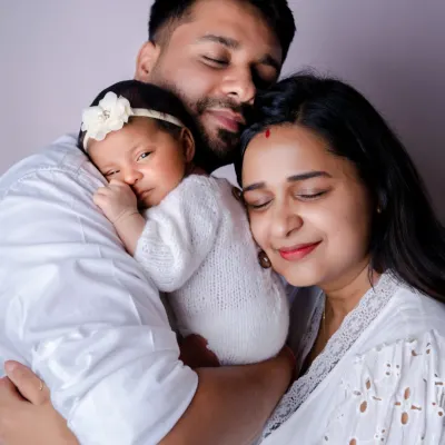 A new family wrapped in a loving embrace, cherishing their tiny miracle. Our newborn sessions are designed to be calm and peaceful, capturing the pure love that fills the room.