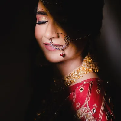 A serene bridal portrait. We used soft lighting to capture this quiet moment of happiness, focusing on the bride's beautiful smile and traditional nath.