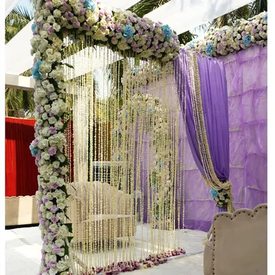 A breathtaking Nikah ceremony setup. The delicate curtain of white floral strings creates an ethereal and intimate space, framed by a beautiful arch of pastel flowers.