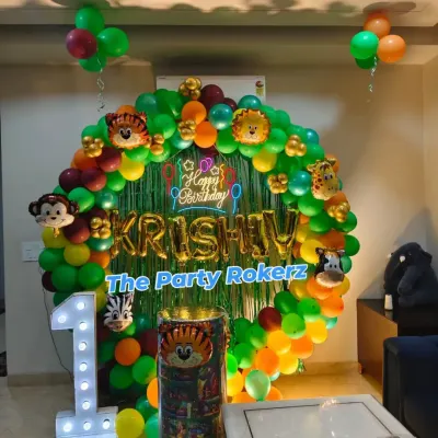 A classic jungle theme setup for a first birthday at home. I used a round balloon arch with lots of green, animal foil balloons, a custom backdrop, and a light-up number '1'.