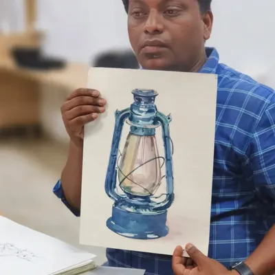 Our instructor, Sushil, holds up a finished watercolor study of a lantern. In his sessions, he breaks down complex objects into simple shapes and values, making realistic painting accessible even for beginners.