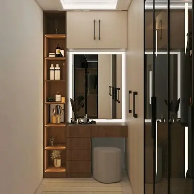 A compact dressing area with a built-in vanity and wardrobe. The illuminated mirror and open shelving provide a perfect spot for getting ready.
