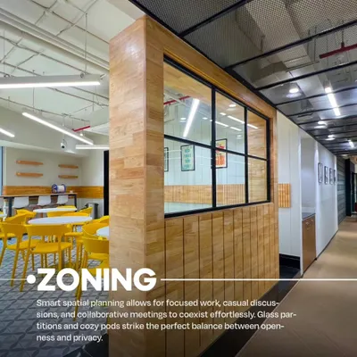 A view of the VentureX coworking space in Gurugram, showcasing our use of zoning. A wooden partition with a window creates a semi-private meeting area next to a more open cafe-style zone with bright yellow chairs.