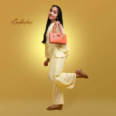 A cheerful full-length studio shot for youth fashion, highlighting a complete outfit and accessory. The warm, golden background and playful pose make this image perfect for a children's clothing catalogue or brand campaign.