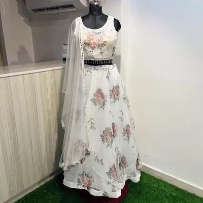This white floral lehenga is a dream for a day wedding. The light organza fabric and soft floral print are complemented by a sequined blouse and a stylish embellished belt.
