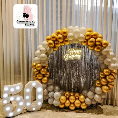 This elegant 50th birthday setup is one of my most requested designs. The classic combination of a gold and white balloon ring, a bright neon sign, and large marquee numbers creates a sophisticated focal point for any milestone party.