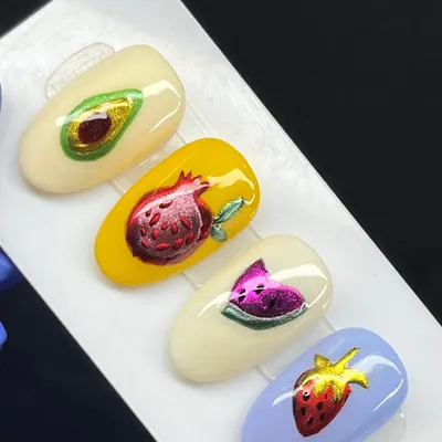 A set of juicy, fruit-inspired nails with a metallic chrome finish, featuring avocado, pomegranate, watermelon, and strawberry designs.