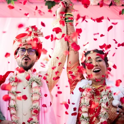 The moment of celebration. An explosion of rose petals as the couple is officially declared married. This is pure joy.
