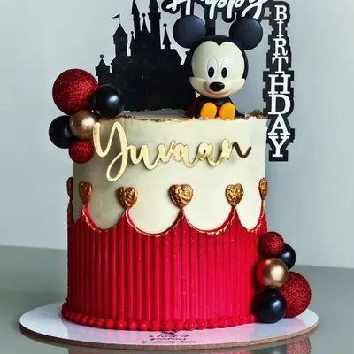 A classic Mickey Mouse theme with a modern twist. This cake features a clean red and white design with a striped buttercream texture, gold hearts, and a silhouette of the Disney castle for a touch of magic.