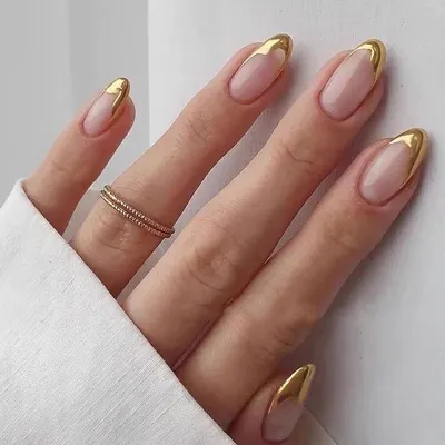The ultimate in luxury. These almond-shaped nails feature a flawless nude base with a striking, liquid-gold chrome French tip.