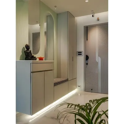 I designed this entryway to be highly functional. It features a built-in bench with seating for putting on shoes, concealed storage below, and an arched mirror. The pastel green accent and under-cabinet lighting create a bright and welcoming atmosphere.