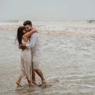 A deeply romantic and candid moment of the couple embracing in the waves. This pre-wedding beach photo is all about raw emotion and the feeling of being lost in each other.