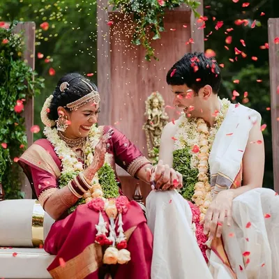 A joyful moment as a couple is showered with petals during their South Indian wedding ceremony. Our venue is a canvas for such beautiful, candid moments.