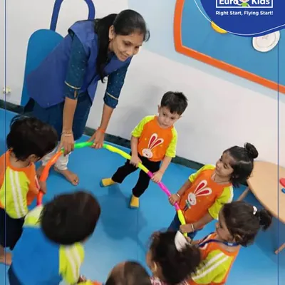 Learning is a team sport. Here, children and teachers engage in a group activity during our 'Circle Day', holding a hula hoop together to understand the shape in a collaborative and physical way.