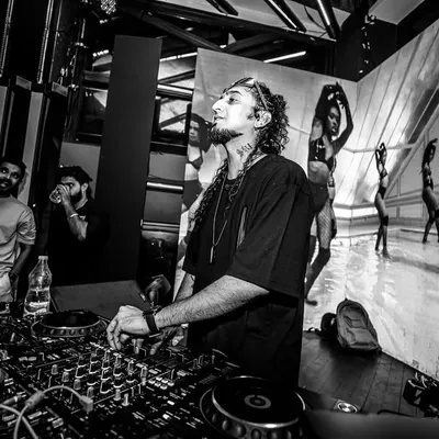 A black and white shot of me at the decks with a massive video wall behind me. The visuals are just as important as the music in my sets.