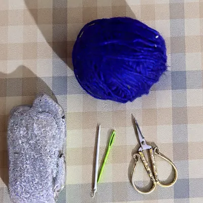 The materials for this project are beautifully simple: a smooth stone, some colorful yarn, a needle, and scissors. This shows that you can create something meaningful with just a few basic elements and a bit of time.