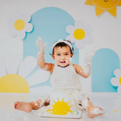 Hands up if you love cake. This little ray of sunshine is having a blast during her daisy and sun themed cake smash session, a perfect theme for a bright and happy baby.