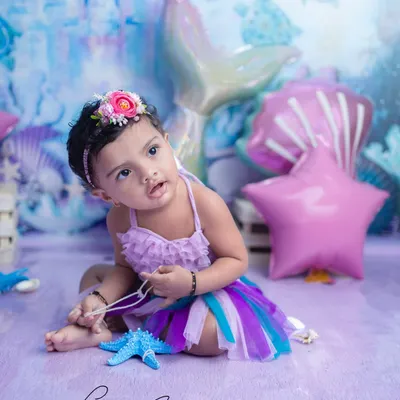 A magical 'Little Mermaid' session. The iridescent tail, seashell props, and underwater castle backdrop come together to create a truly enchanting world for this little one.