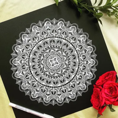 A beautiful 12-inch white mandala on black paper. The contrast is so powerful, and the intricate details create a delicate, lace-like appearance.