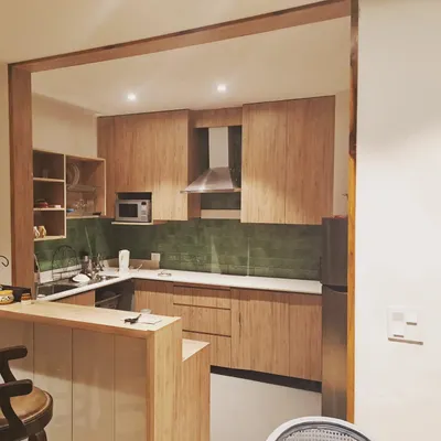 This modern kitchen is a great example of our interior work. It features custom bamboo-finish cabinets, a sleek breakfast bar, and a distinctive green tiled backsplash, all designed to create a beautiful and highly usable space.