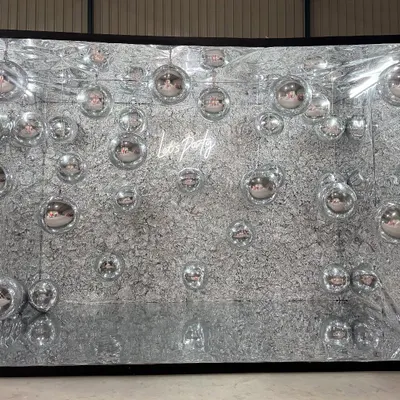 Step into the spotlight with our mirror photo booth box. The interior is lined with a textured silver material and reflective disco balls, creating a stunning, immersive environment for party photos. The "Let's Party" neon sign adds a fun touch.