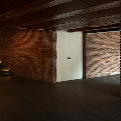 The entrance area of the Samavana wedding venue, featuring exposed brick walls and a wooden ceiling. The design blends contemporary lines with traditional materials to create a warm and welcoming atmosphere.