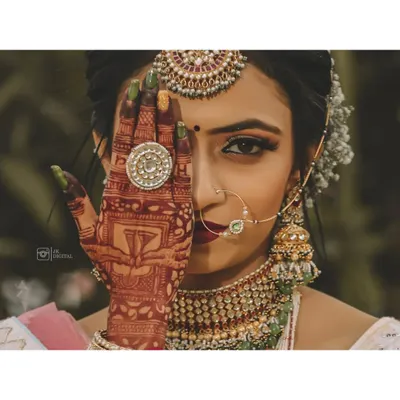 It's all in the details. This bridal portrait focuses on the intricate mehendi design, the stunning jewelry, and the quiet confidence of the bride, preserving the artistry of her wedding look.