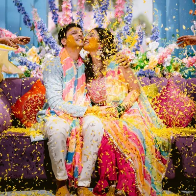 A shower of love and marigold petals. This shot from Laxmi and Roshan's Haldi is the epitome of joyful celebration, with vibrant colors and pure happiness.