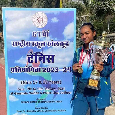 A monumental win for Manshi Singh, who won the Gold Medal for the Delhi U19 team at the School Games Federation of India in Jodhpur. She holds her medal and a massive trophy, representing the pinnacle of school-level tennis.